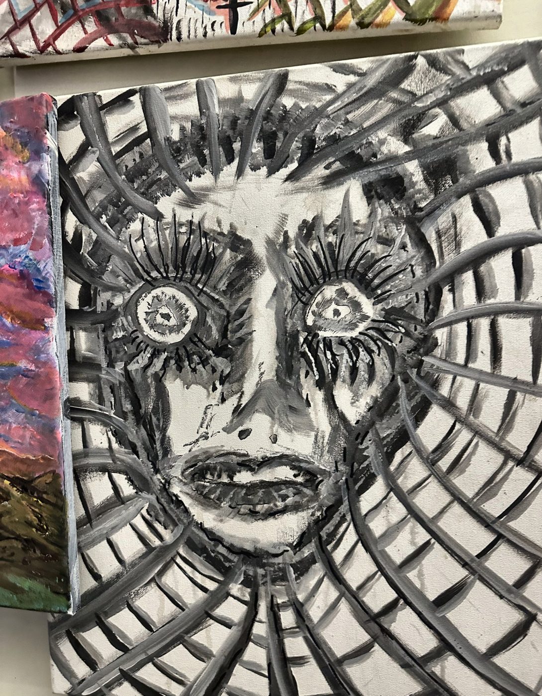 Black and white acrylic painting of a face drawn through a web of lines